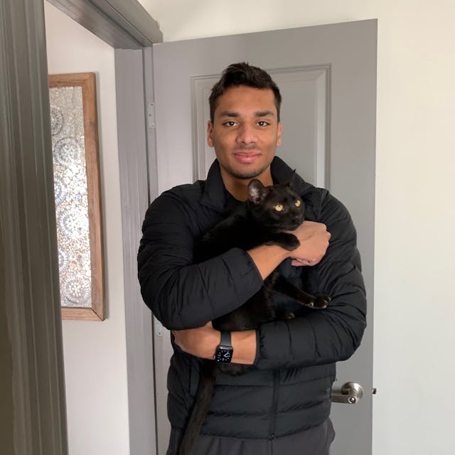 Devin with a small black cat named Shadow